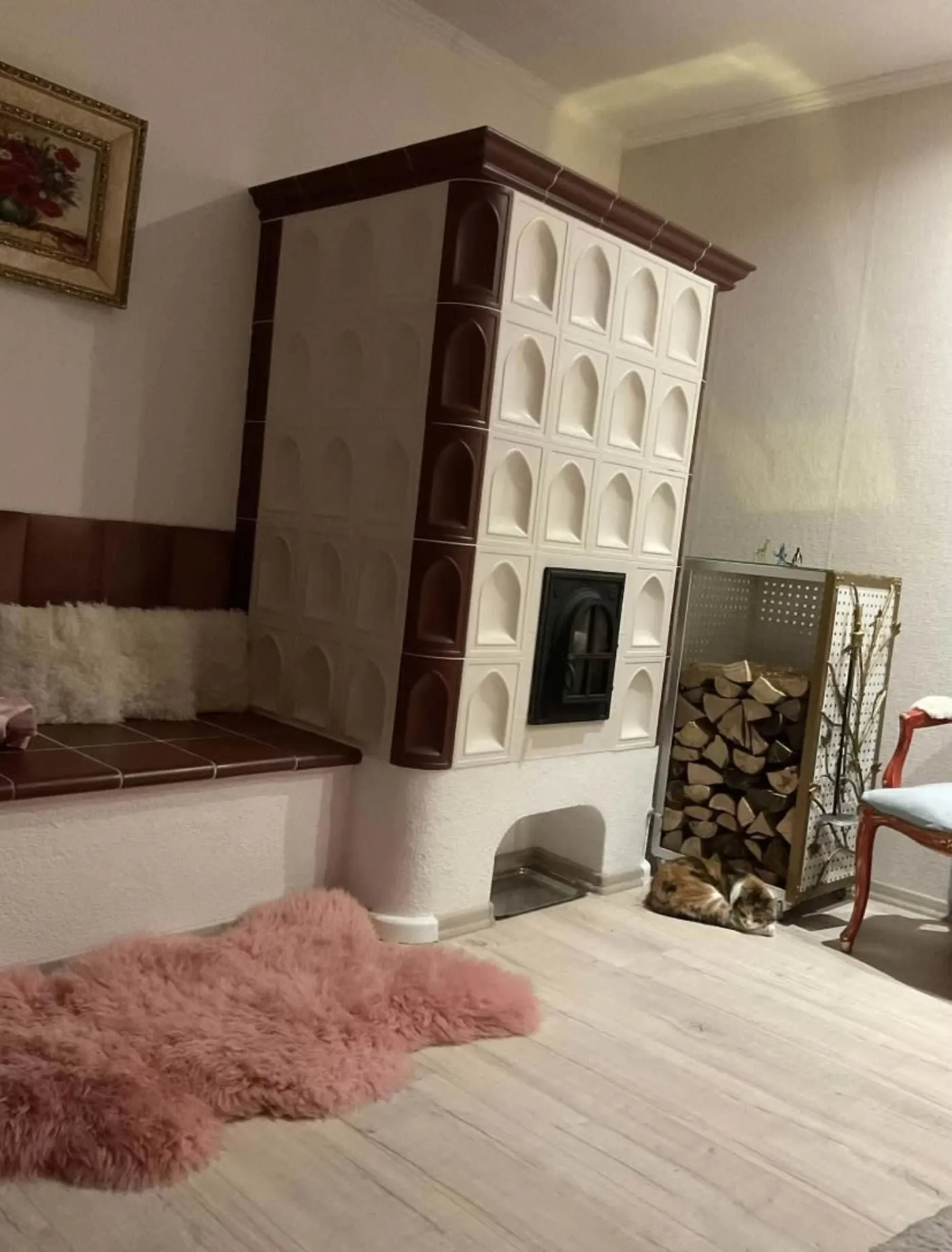 Krémová kachľová pec s reliéfnymi kachlicami a lavicou